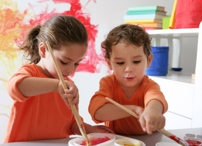 Fraternal twins playing with paints